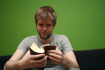 young man reading small bible