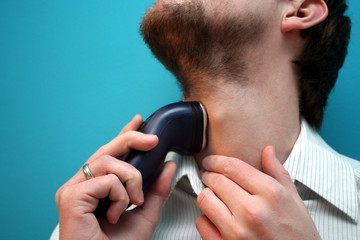 man using electric shaver
