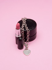 a lipstick and an herat-shaped jewel, symbolizing