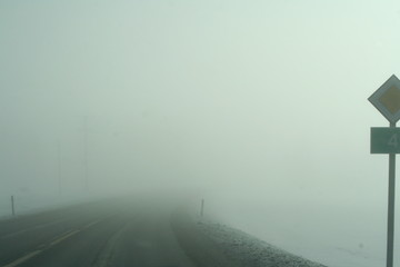 bad visibility on the road with fog and traffic sign