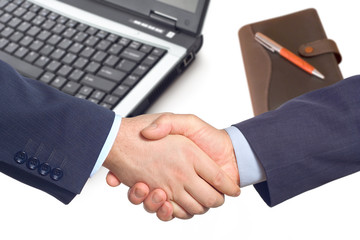 business handshake  with a laptop and a notepad