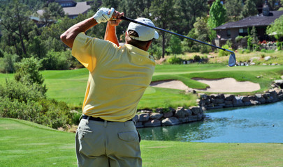 close-up of a golfer hitting over water