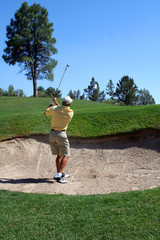 golfer successfully hitting golf ball out of a san
