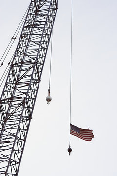 old glory and a crane tower