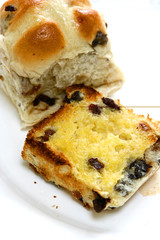 Warm hot cross buns with melted butter