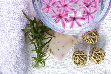 spa items. towels, lavender soap, water, flowers..