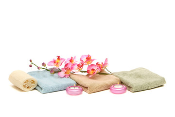 spa towels, candles, loofah and pink orchid