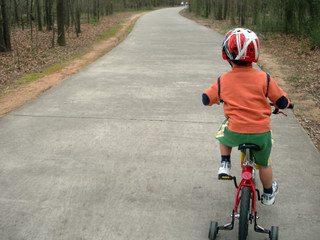 little boy learning to ride bicycle