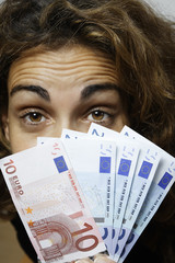 women hiding behind euro bills