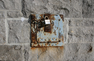 iron lock and rusty chain on a stone wall