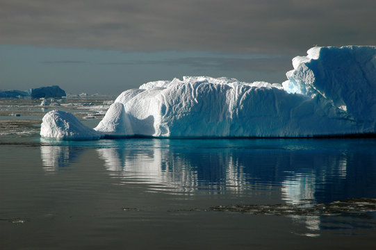 iceberg in sunlight with water reflection