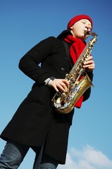 Naklejka premium girl plays on a saxophon