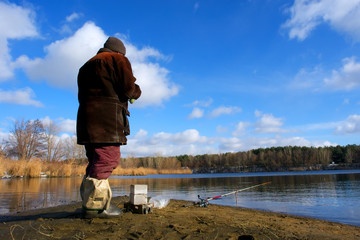 a fisherman looks after a rod on the shore