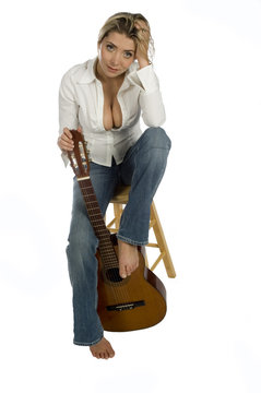 female guitarist sitting on stool smiling