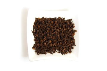 whole cloves in square white bowl isolated