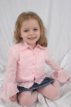 cute little girl sitting on white background.