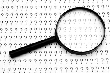magnifying glass and question marks