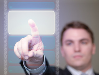 businessman pushing glowing button on translucent screen.
