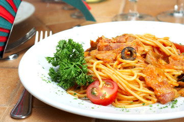 spaghetti with a tomato sauce on a table in cafe