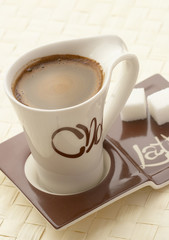 choco latte. a white cup of coffee on a support.