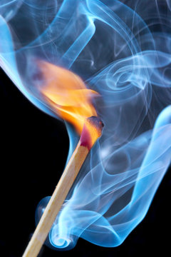 photo of a burning match in a smoke on a black background