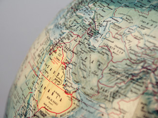 closeup of world globe focused on middle east with grey backgrou