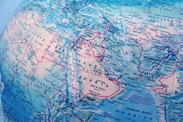 closeup of world globe focused on middle east with blue backgrou