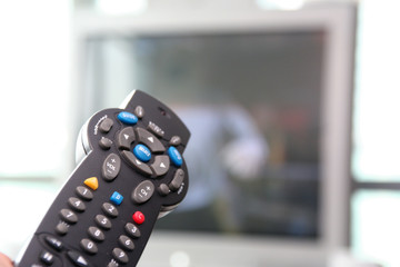 tv remote control with tv in background