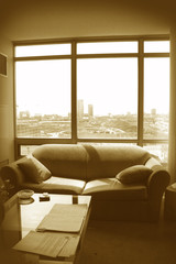 couch in apartment with city in the background in sepia