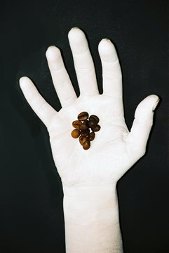 coffee beans on a white hand