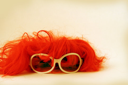 Isolated Red Wig Toupee And Sun Glasses