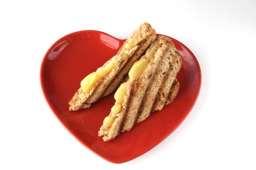 sandwich with melted cheese on heart shape plate