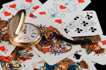 golden watch and playing cards