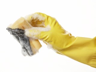 hand in yellow rubber glove with yellow sponge and