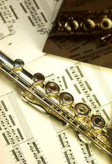 flûte et métronome devant une partition de musique