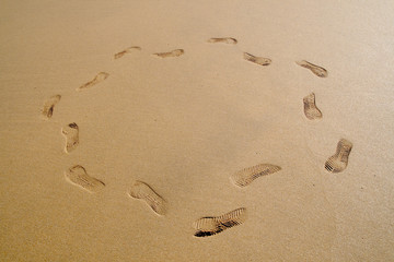 Fototapeta na wymiar ślady na plaży, chodzą w circl