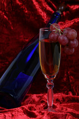 blue bottle of wine, glasses and grapes