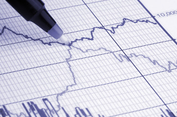 pen showing diagram on financial report/magazine