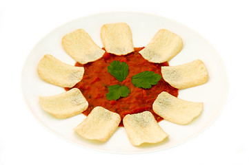 chips and salsa dip with coriander leaf garnish.
