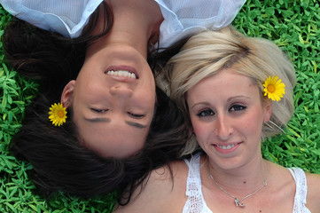 two girlfriends lying on the grass