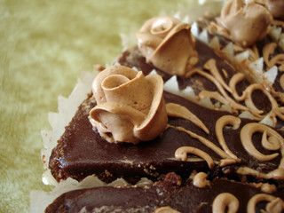 part of chocolate cake with flowers on textured background