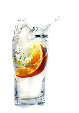 splashing orange into a water glass
