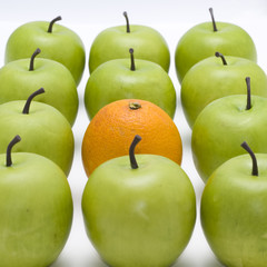 lots of green apples with one orange