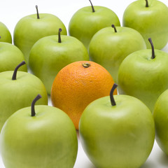 lots of green apples with one orange