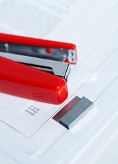 red stapler with a bunch of staples macro 2