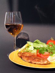 paniertes schnitzel mit salat und wein