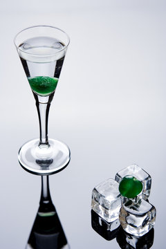 vodka with green cherry and ice cubes