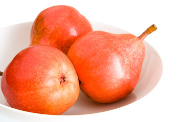 three red pears on a plate