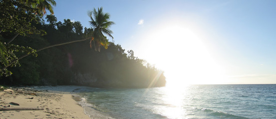 tropical beach with facing sun, togians island, sulawesi, indone