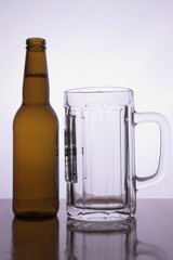 a bottle of cold beer with no lables and a pitcher